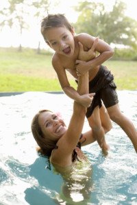 Mother and young son playing in the pool